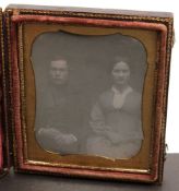 A Victorian quarter plate daguerreotype of a seated couple in an embossed leather case:.