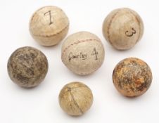 A feathery golf ball, a later moulded golf ball and four Eton Fives handballs,