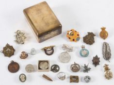 An Ardath cigarette case: containing a collection of military cap and lapel badges,