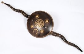 In Indian Madu: the central circular shield with four brass bosses and mounted with horns, 79cm.