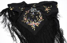 A Chinese silk shawl: with floral embroidered decoration to a black silk ground, and tassel fringe,