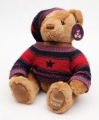 A brown plush Harrods Christmas bear 2004:, in a red and purple jumper and bobble hat.