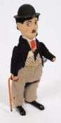 A clockwork figure, Charlie Chaplin:. with bowler hat and walking stick, 17cm. high.