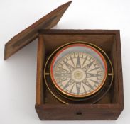 A 4 1/2 inch dry card compass:, unsigned, in a gilt brass gimbal in an oak case,