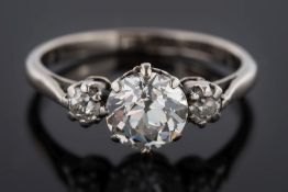 A platinum and diamond three-stone ring: with central,