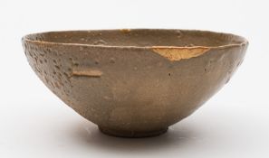 A Chinese pottery bowl, probably Song Dynasty: of circular form under patchy celadon glazes,