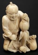 A Japanese carved ivory okimono of a fruit seller: kneeling with axe in one hand and gourd in the