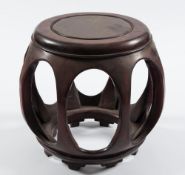 A Chinese hardwood stand: of circular outline with open oval panels to the sides, 39cm. diameter.