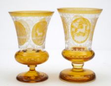 Two Bohemian amber flashed goblets: decorated with alternating oval panels of deer and buildings on