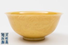 A Chinese porcelain sgrafitto decorated yellow ground bowl: the exterior incised with a pair of