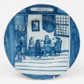 A Delft delft 'month' plate for February: painted in blue with figures smoking in an interior,