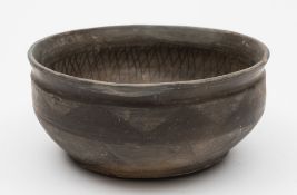 A Chinese grey pottery bowl: in Han Dynasty style with incised and burnished geometric decoration,