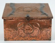 An Art Nouveau period copper coal box: the sloping hinged fall with stylised flower and strap work