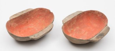 A pair of Chinese pottery winged cups: of ovoid shape, the interiors with red pigmentation,