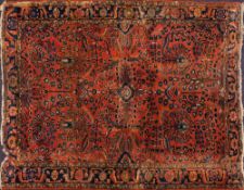 A Sarouk Mahal rug:, the brick red field with all over geometric designs and floral foliate stems,