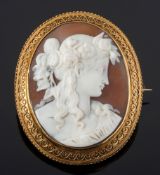 An oval shell cameo portrait brooch: depicting a classical woman,