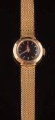 Omega. A lady's 18ct gold wristwatch: the circular black dial 14.