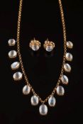 An early 20th century gold and moonstone fringe necklace: with thirteen oval moonstones graduated