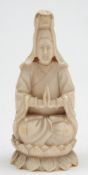 A 19th century Chinese carved ivory figure: possibly Guanyin, seated cross legged on a lotus flower,