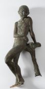 An abstract bronze figure of a young boy: leaning against a tree stump, unsigned and undated, 64cm.
