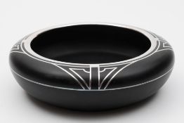An Art Deco black and silver overlaid bowl: of shallow circular form the shoulders and neck with