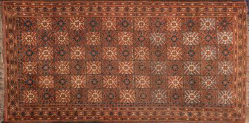 A Beshir rug:, the brick red field with square radiating stellar design panels,