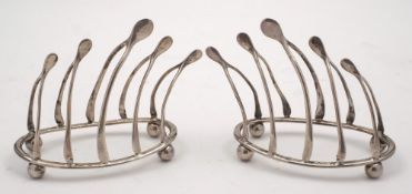A pair of Edward VII silver four-division wishbone toast racks, maker William Hutton & Sons,
