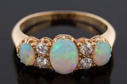 A gold, opal and diamond seven-stone ring: claw-set with graduated,
