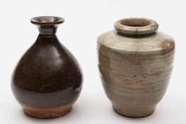 A Chinese porcelain vase and a jar: the former of tear drop form with flaring neck under brown
