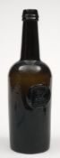 A sealed cylinder wine bottle: the mid green body of three piece moulded construction with applied