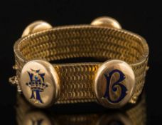 A 19th century gold mesh bracelet: with four applied enamelled oval lockets,