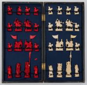 An early 20th century Chinese ivory chess set: one side stained red, the other natural ivory,