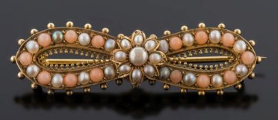 A gold, pearl and coral mounted ribbon bow brooch: in fitted case.
