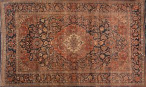 A pair of Kashan rugs:, the indigo cartouche fields each with a rust cartouche pole medallion,