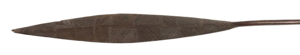 A Maori war paddle: the oval shaped blade with carved geometric decoration to both sides having a