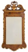 A late 19th Century walnut and carved giltwood mirror:, in the early 18th Century taste,