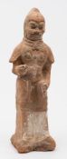 A Chinese painted pottery figure of a standing warrior: with pronounced eyebrows and curled