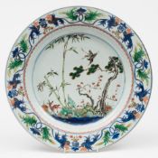 A Chinese famille verte charger: enamelled with a deer and crane amongst bamboo, pine, prunus,