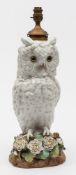 An English porcelain paraffin lamp in the form of a Long Eared Owl: modelled perched on a rustic