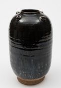 An Oriental Henan-style black glazed jar: of ovoid form, the shoulders applied with four eared lugs,