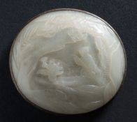 A Chinese jade oval plaque: carved with a figure paddling a boat within a lake landscape,