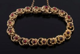 A 19th century gold and cabochon garnet mounted bracelet: of stamped flower-head links,