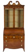 An early 19th Century mahogany, satinwood decorated and inlaid cylinder fronted bureau bookcase:,