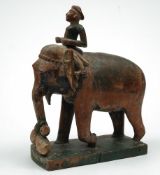 An Indian carved and polychrome decorated wood elephant: with seated rider, on a rectangular base,