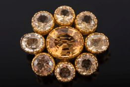 A late 19th century gold and topaz oval cluster brooch: with central oval topaz approximately 12mm