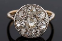 A diamond circular cluster ring: pave-set with eight round old brilliant-cut diamonds estimated to