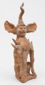 A Chinese painted terracotta figure of an earth spirit: with twisted horn and elongated ears,