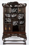 A late 19th Century Japanese carved wood and decorated cabinet on stand:,
