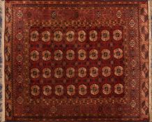 A Turkoman rug:, the red field with four rows of quartered medallions,