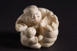 A Japanese okimono of a grain merchant and young boy: seated with a sack of grain and box of grain